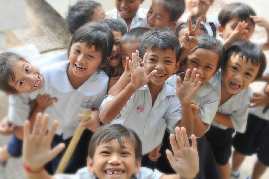 Children smiling and waving at the camera 