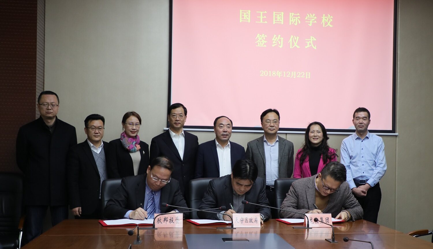 Three men sign as agreement for a new Dipont Education has signed an agreement to open the new independent school in Changzhou