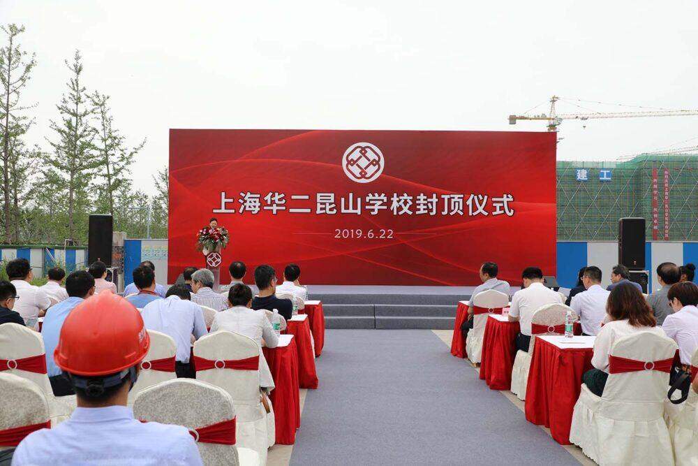 People sit in rows of chairs listening to a speaker at the podium