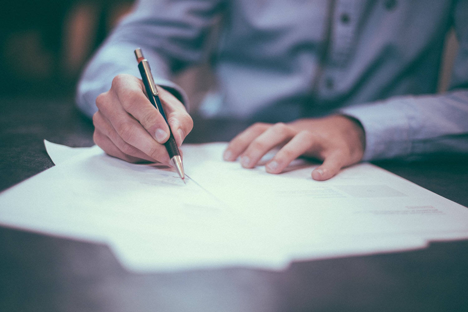 A man signing a fake teaching contract