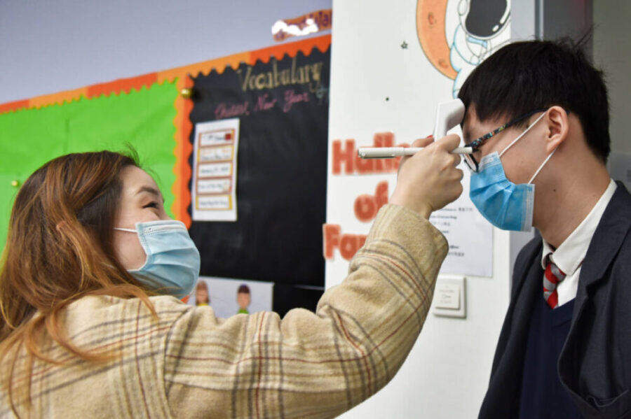 A pupil at Nanwai King's College School Wuxi has his temperature checked